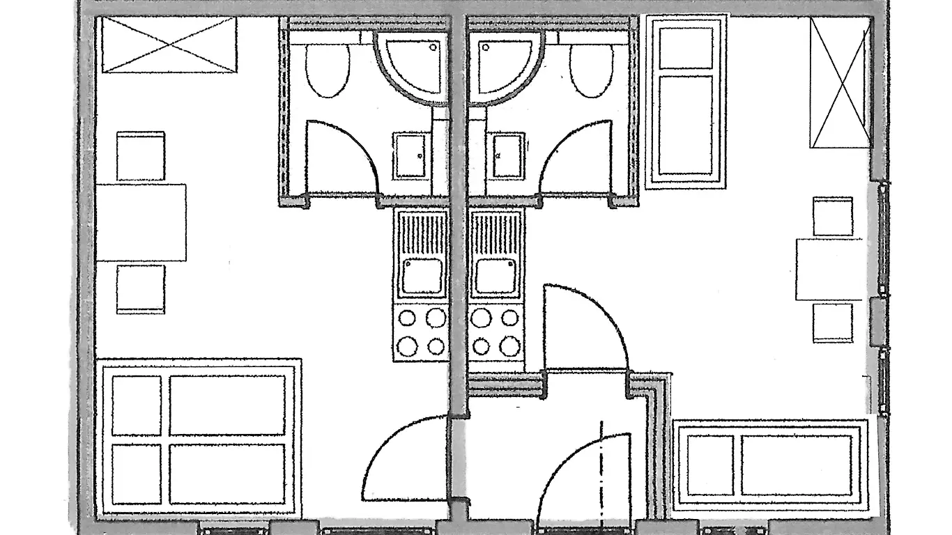 Grundriss einer kleinen Wohnung mit zwei separaten Badezimmern, Küchenzeilen und zwei Wohnbereichen mit Tischen, Stühlen und Betten.